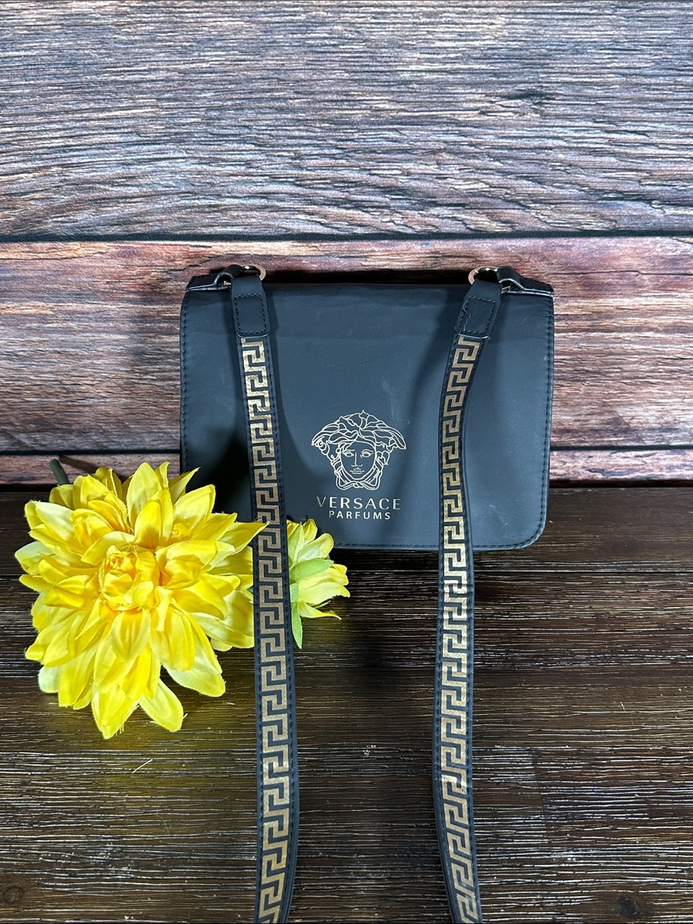Versace Parfums crossbody bag features the iconic Gold Medusa logo